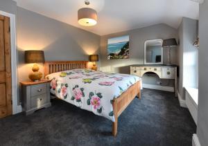 a bedroom with a bed and a desk and a mirror at 2 Bryn Hyfryd in Llanbedrog