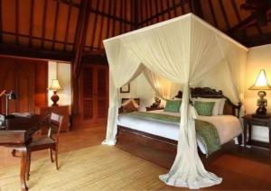 a bedroom with a bed with a canopy at Ibah in Ubud