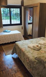 a bedroom with two beds and two windows at Casa Goldoni Gramado in Gramado