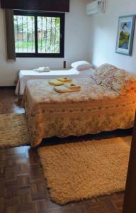 1 dormitorio con cama, ventana y colcha en Casa Goldoni Gramado, en Gramado