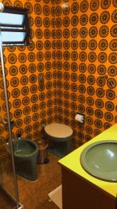 bagno con due servizi igienici e lavandino verde di Casa Goldoni Gramado a Gramado