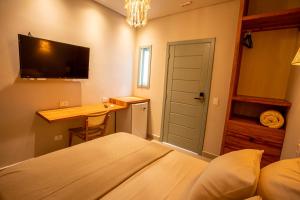 a bedroom with a bed and a desk and a television at Casa Savana in São Paulo