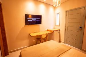 a bedroom with a desk and a tv on the wall at Casa Savana in São Paulo