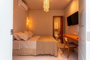 a bedroom with a bed and a desk and a television at Casa Savana in São Paulo