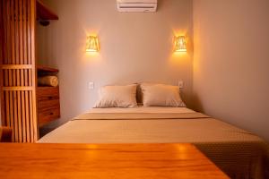 a bedroom with a bed with two pillows and two lights at Casa Savana in São Paulo