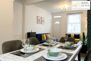 a dining room table with plates and glasses on it at 2 Modern Double Bed Apartment for 5 Guests By Hofin Stays Short Lets & Serviced Accommodation in Dartford