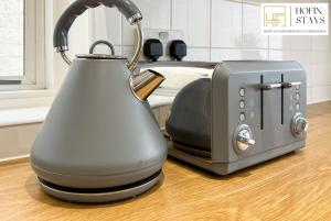 a tea kettle next to a toaster on a kitchen counter at 2 Modern Double Bed Apartment for 5 Guests By Hofin Stays Short Lets & Serviced Accommodation in Dartford