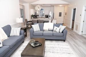 a living room with two couches and a kitchen at Stunning Condo on Golf Course Near Broadway at the Beach in Myrtle Beach