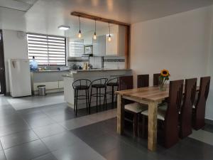 a kitchen and dining room with a table and chairs at Elegante apartamento con vistas al volcán Tungurahua in Baños