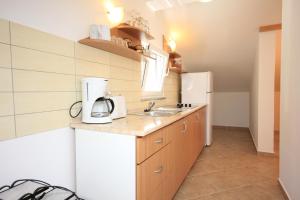 a small kitchen with a sink and a refrigerator at Apartment Artatore 8022d in Čunski