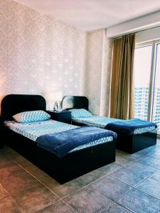 Duas camas num quarto com uma janela em Travelers Backpackers em Dubai