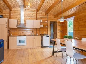 a kitchen with a table and chairs and a wooden wall at Holiday home Toftlund XLIV in Toftlund