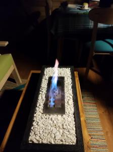 Una vela sobre una mesa en una habitación con rocas en La Cabaña de Huckleberry, en El Retiro
