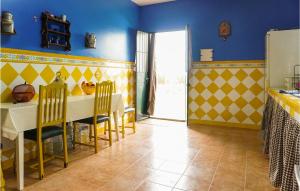 une cuisine avec des murs jaunes et bleus, une table et des chaises dans l'établissement Lovely Home In Arahal sevilla With Wifi, à Morón de la Frontera