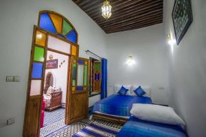 1 dormitorio con 2 camas y vidriera en Dar Miouda Fes, en Fez