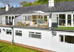 a white house with an open patio and an umbrella at 4 Glyn y Marian in Llanbedrog