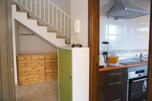 a kitchen with a stairway and a kitchen with a refrigerator at Casa Playa in Caleta De Fuste