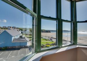 a room with windows looking out at the beach at 32 St Brides Bay View Apts in Broad Haven