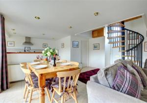 a kitchen and living room with a wooden table and chairs at 3 Tyn Llan in Dyffryn