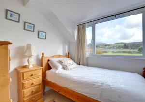 a bedroom with a bed and a large window at 3 Tyn Llan in Dyffryn