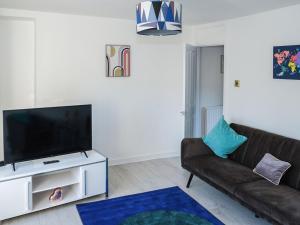 a living room with a couch and a flat screen tv at Doon on The Loch in Dunoon