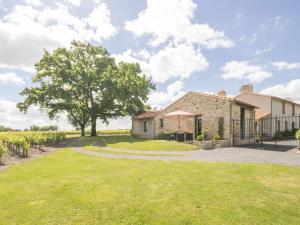 una casa con un árbol y un patio de césped en Gîte Château-Thébaud, 3 pièces, 4 personnes - FR-1-306-803 en Châteauthébaud