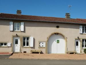 a building with a white door and a bench in front at Gîte de Charme avec Terrasse près de Bourbonne-les-Bains, 2 chambres, poêle à bois, Wifi inclus - FR-1-589-118 in Lironcourt
