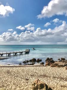 a beach with a pier and a boat in the water at EcoLuxe in Dunsborough