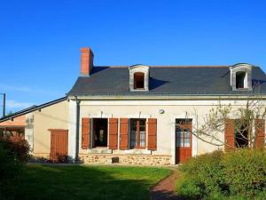 Una gran casa blanca con persianas rojas. en Gîte Baugé en Anjou, 5 pièces, 9 personnes - FR-1-622-28 en Baugé-en-Anjou