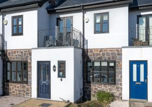 een huis met blauwe deuren en ramen bij 5 Afon y Felin in Abersoch