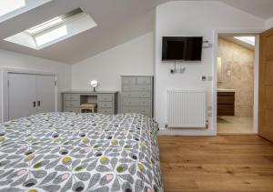 a bedroom with a bed and a television on the wall at 9 Pen y Bont in Abersoch