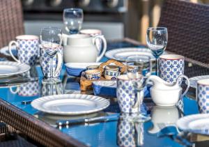 una mesa con anteojos y platos azules y blancos en 9 Braich Farm, en Llanengan