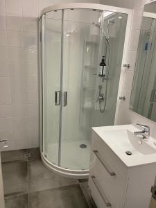 y baño con ducha acristalada y lavamanos. en West End Precinct 2 Bedroom Apartment close to walkway and ocean, en New Plymouth