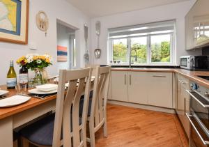 a kitchen with a table and chairs and a kitchen with a sink at 78 Cae Du in Abersoch