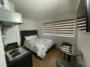 Dormitorio pequeño con cama y mesa en TinyApartments - estudio pleno centro Concepción en Concepción