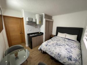 um pequeno quarto com uma cama e uma mesa em TinyApartments - estudio pleno centro Concepción em Concepción