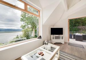 a living room with a large window and a tv at Apartment 4 The Old Stables in Aberdyfi