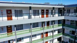 an apartment building with red doors and balconies at Vila Nóbrega Residencial in Foz do Iguaçu