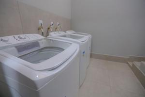 a white washer and dryer in a bathroom at Vila Nóbrega Residencial in Foz do Iguaçu