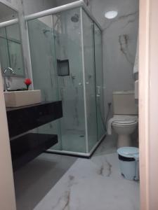 uma casa de banho com uma cabina de duche em vidro e um WC. em Bahia Flat 301 em Salvador