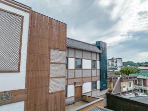 un edificio con una fachada de madera en la parte superior de un edificio en HotelArrive Jeonju Sihwayeonpung, en Jeonju