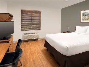 1 dormitorio con 1 cama y escritorio con TV en Extended Stay America Select Suites - Indianapolis - Greenwood, en Greenwood