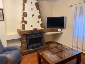 sala de estar con chimenea y TV en Villa Emilia, en Ruidera