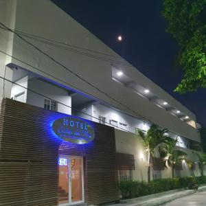 un bâtiment d'hôtel avec un panneau bleu de néon sur celui-ci dans l'établissement Hotel Suites del Mar, à Palmas