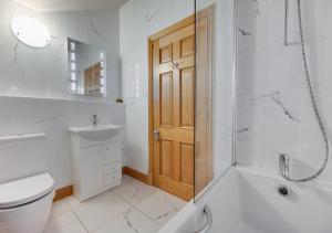 a bathroom with a toilet and a shower and a sink at Awelon y Mor in Aberaeron