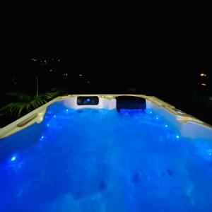 德豪特漁村的住宿－Ti karet - Charmant logement avec Jacuzzi et vue mer，浴缸在晚上装满蓝色的水