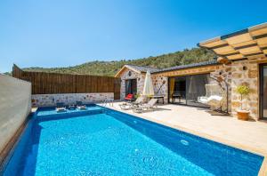 a house with a swimming pool and a patio at Havuzu dışarıdan görünmeyen jakuzili özel havuzlu lüks villa in Kalkan