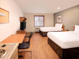 a hotel room with two beds and a kitchen at Extended Stay America Select Suites - Fayetteville - West in Fayetteville