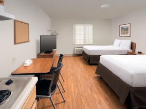 a hotel room with two beds and a desk at Extended Stay America Select Suites - Springfield - South - Battlefield in Springfield