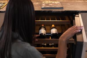 a woman is looking inside of a wine cellar at Chalets at Blackheath in Blackheath